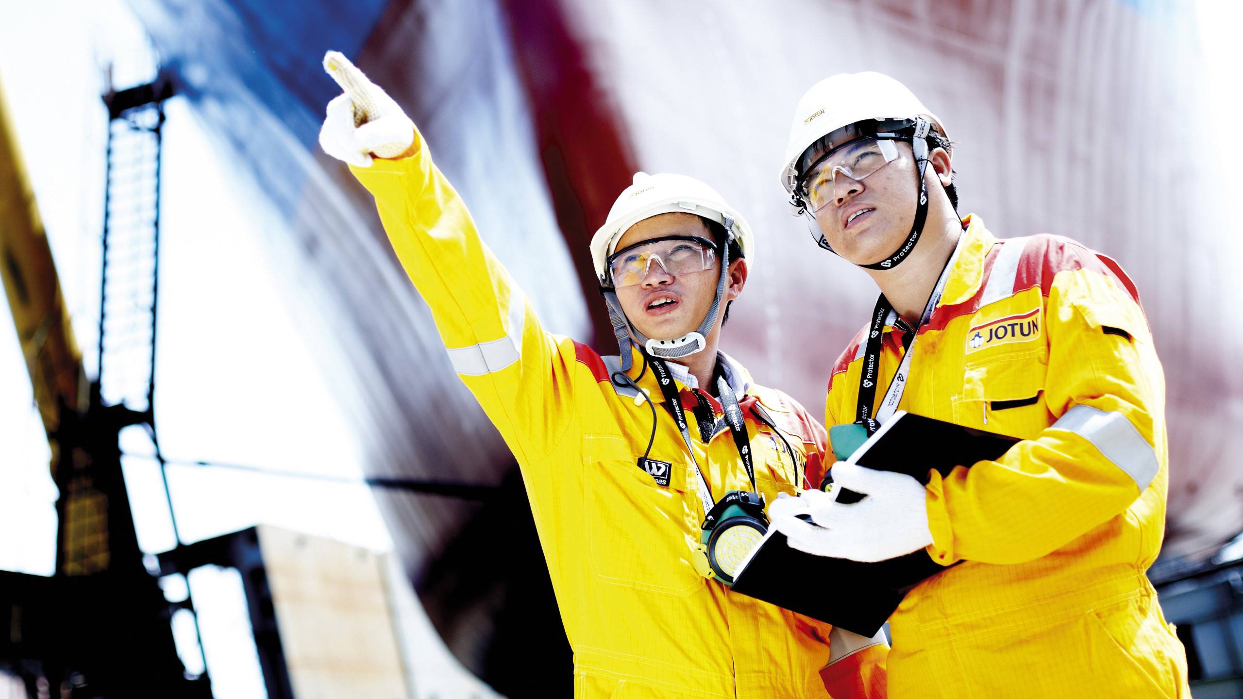 Two engineers, yellow overalls and hard hats